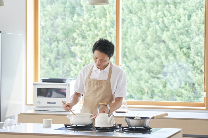 対面キッチンで調理をしている男性