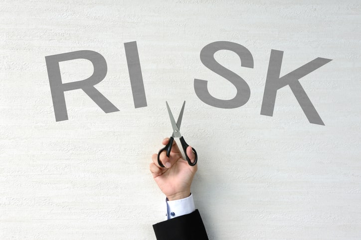 「RISKの文字を半分で切る人の画像」